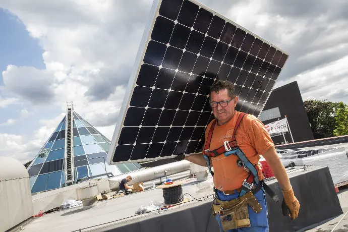 Installateur met zonnepaneel op zijn schouder